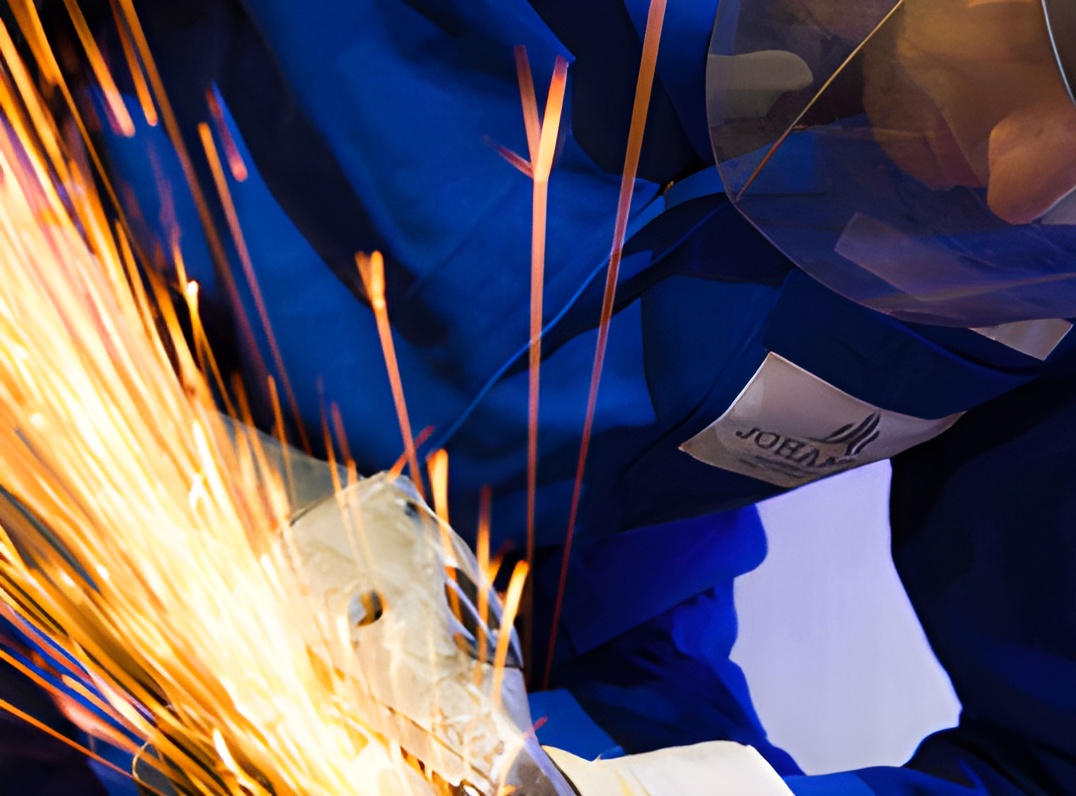WELDING 1 person wearing protective equipment grinding a mild steel product